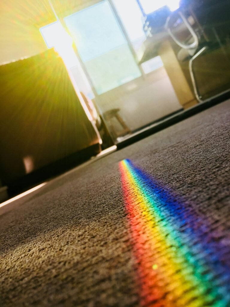 Home A vibrant rainbow reflection on a carpet, created by sunlight passing through crystal glass, adds color to a modern room.